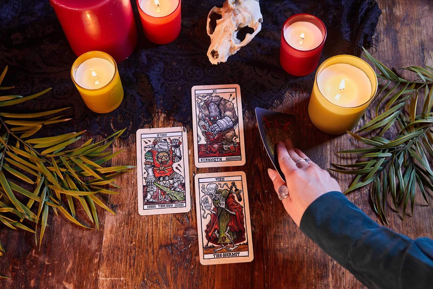Tarot cards on a wooden table with candles and leaves, indicating a mystical or spiritual setting.