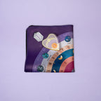 Purple pouch with colorful gemstone design on a light purple background