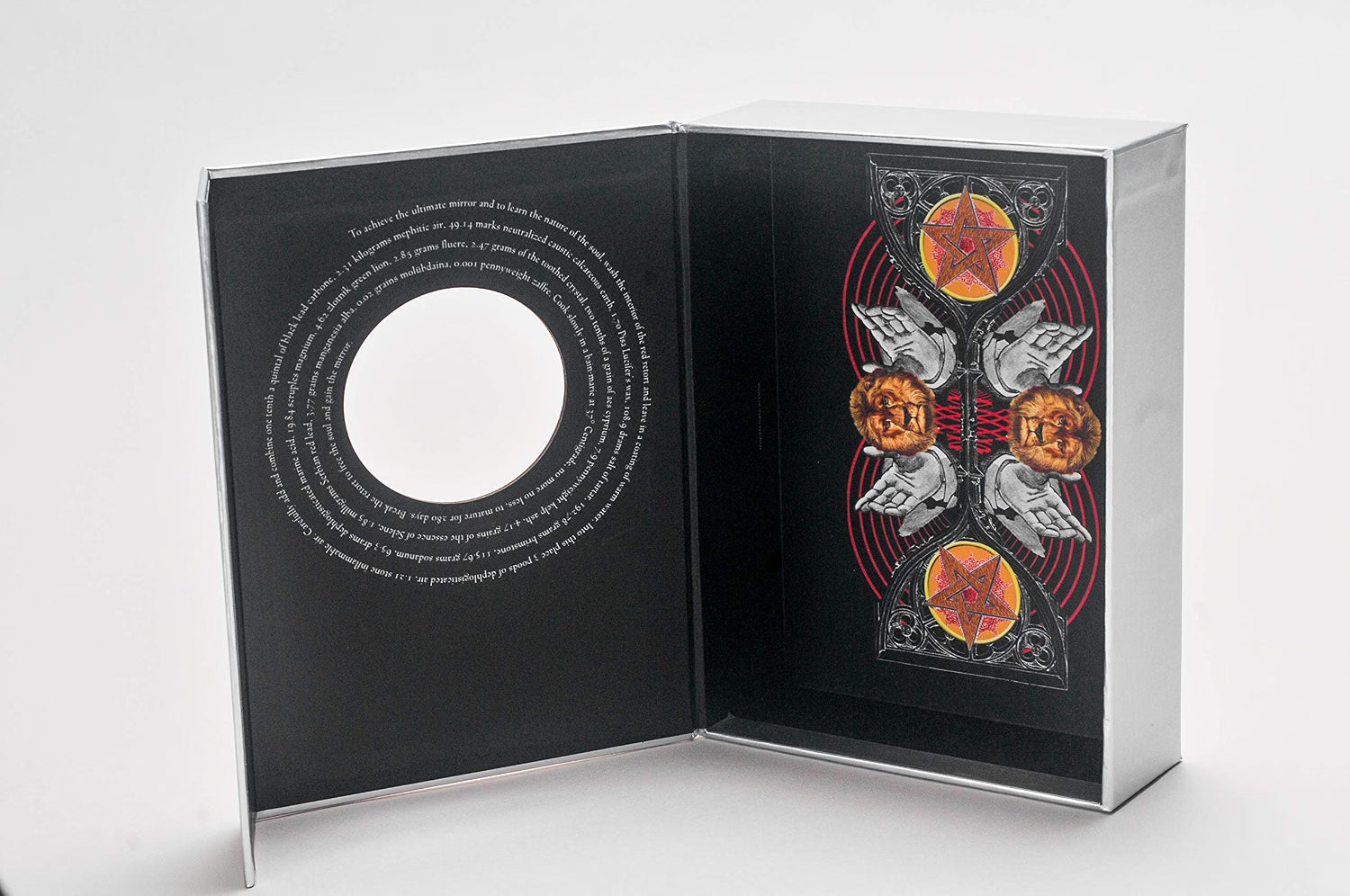 An open black presentation box or album-style package on a light gray studio background, showing printed artwork and text on both interior panels.