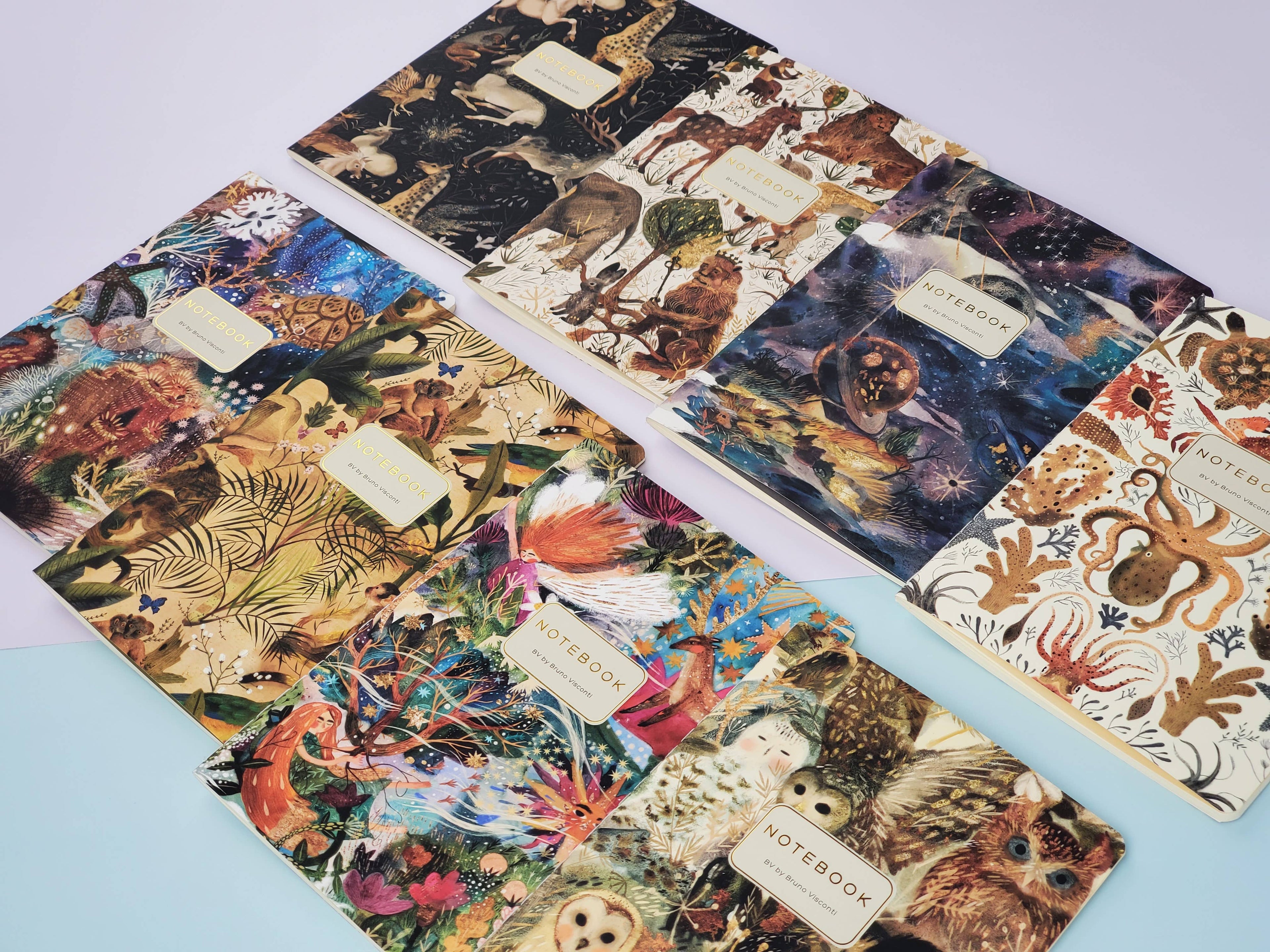 Set of notebooks with animal-themed covers on a light blue surface
