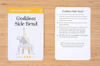 Two cards showing a yoga pose illustration and instructions on a wooden surface