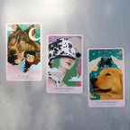 Three tarot cards featuring animals and people on a metallic surface