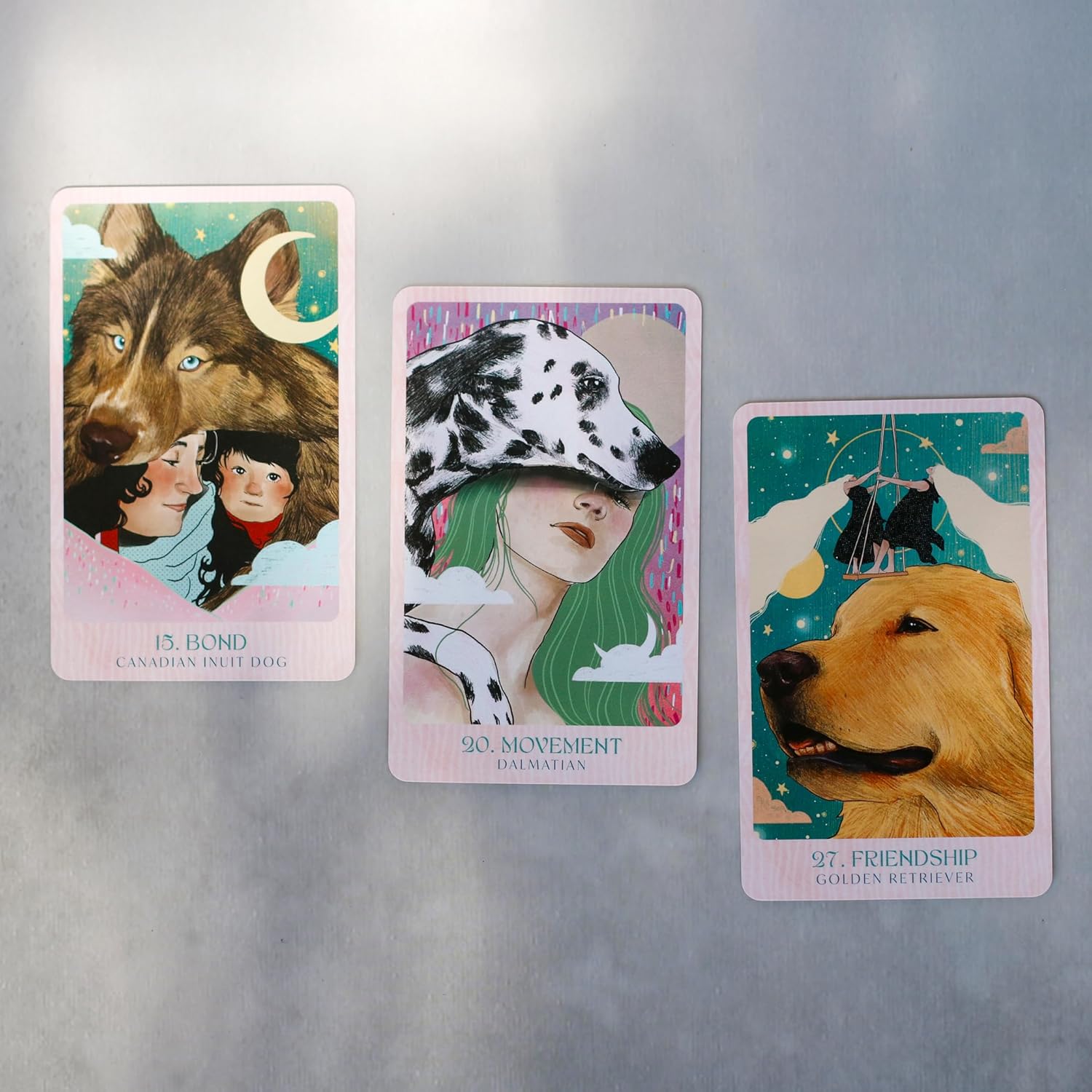 Three tarot cards featuring animals and people on a metallic surface