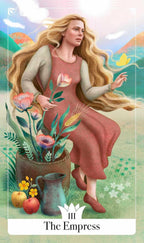 A stylized tarot card illustration titled 'The Empress' showing a woman with long blonde hair in a pink dress standing beside a basket of flowers, with apples, a pitcher, and a bright sky background.