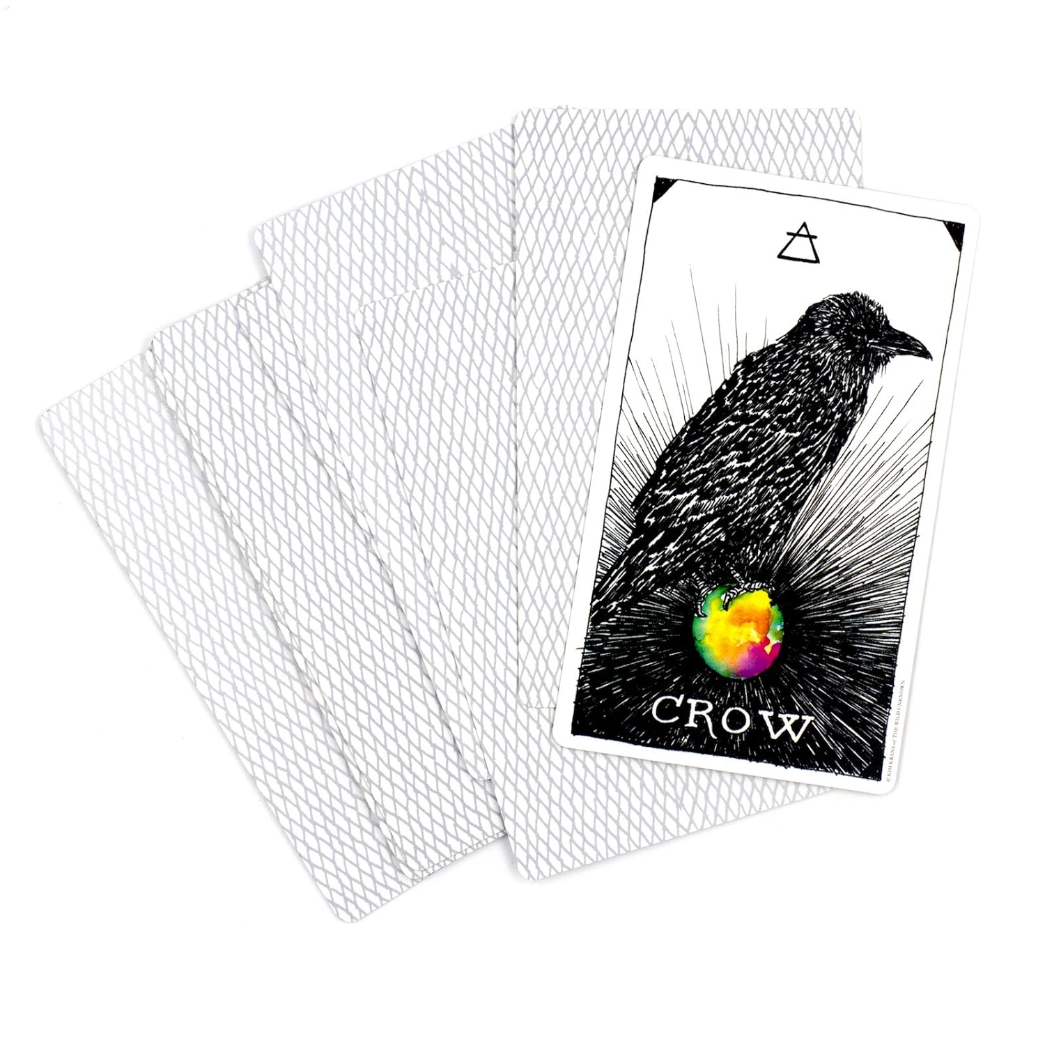 Playing card with a crow design and rainbow heart, surrounded by protective card sleeves.