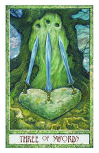 Three blue swords on a green stone with a forest background, tarot card titled 'Three of Swords'.