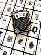 Book on a deck of playing cards with black and white illustrations