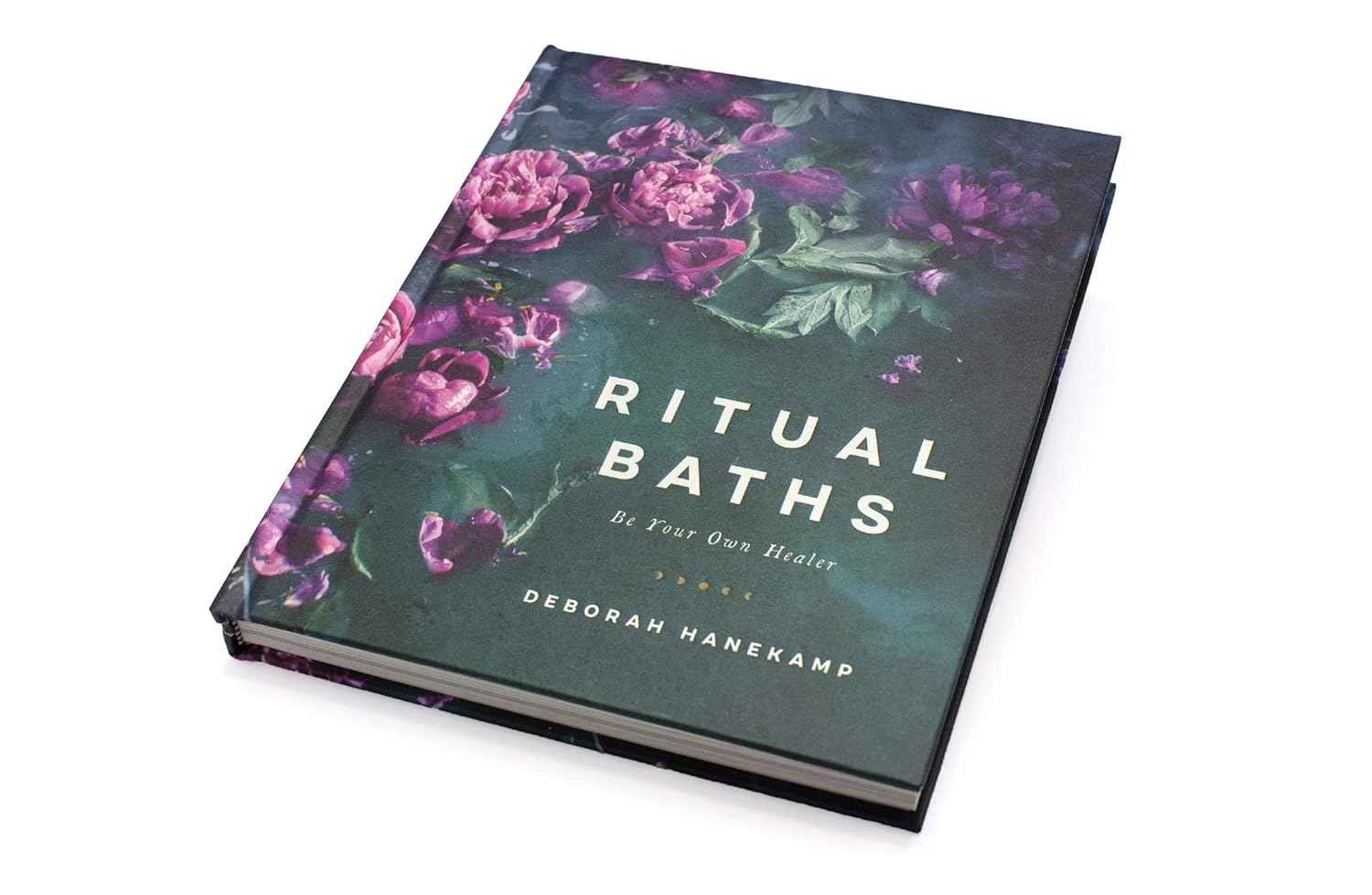 Book titled 'Ritual Baths' with floral design on a white background