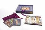 A tarot card deck set displayed on a white background, including a decorative box with a purple ribbon, a matching fabric drawstring pouch, several cards fanned out, and the tarot book 'The Herbarium' lying flat.