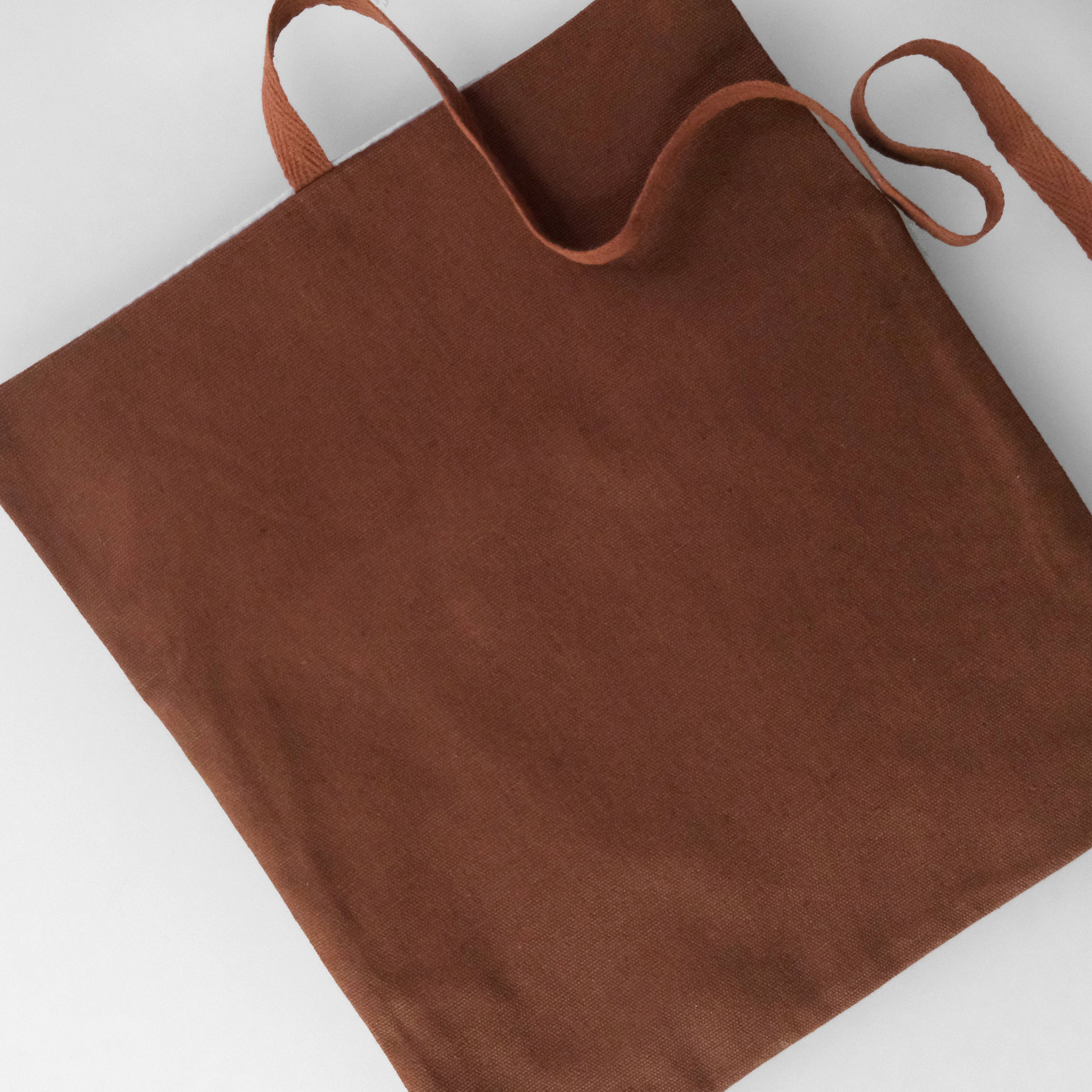 Brown tote bag with handles on a white background
