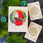 Kate Forsyth's Fairytale Oracle book with two cards on a dark surface with greenery.