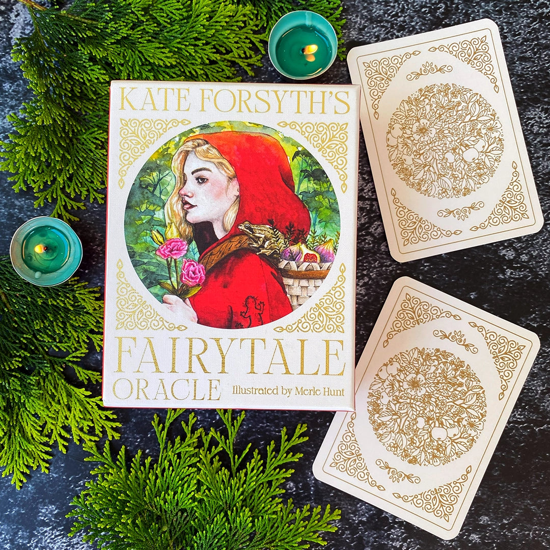 Kate Forsyth's Fairytale Oracle book with two cards on a dark surface with greenery.