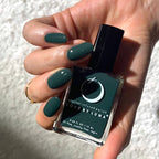 Hand holding a bottle of green nail polish with 'Love by Luna' branding.