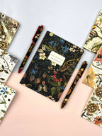 Floral notebook with a pen held by a hand on a white background
