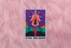 Tarot card titled 'XVIII. The Moon' on a pink furry background
