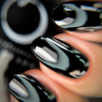 Close-up of glossy black nail polish on a person's fingernail with blurred background
