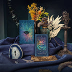Decorative setup with tarot cards, plants, and a candle on a dark background