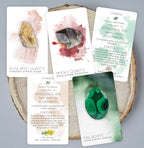 Set of tarot cards with gemstones on a wooden surface