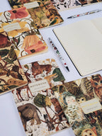 Notebooks with animal-themed covers and a pen on a white surface
