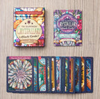 Illustrated Crystallary Oracle Cards packaging and cards on a wooden surface