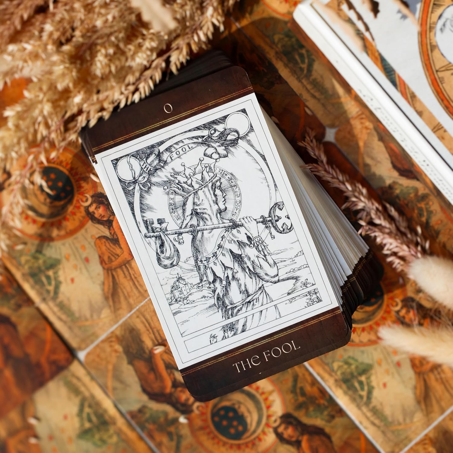 Tarot card deck with 'The Fool' card displayed on a decorative surface