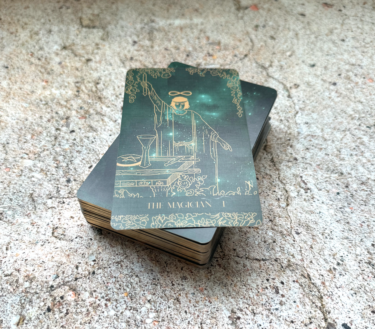 Stack of tarot cards with 'The Magician' card on top, on a textured surface