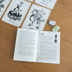 Tarot cards and reading materials on a wooden surface