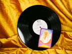 Vinyl record with a picture of a woman on a yellow fabric background