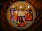 Decorative tray with tarot cards and candles on a dark fabric background