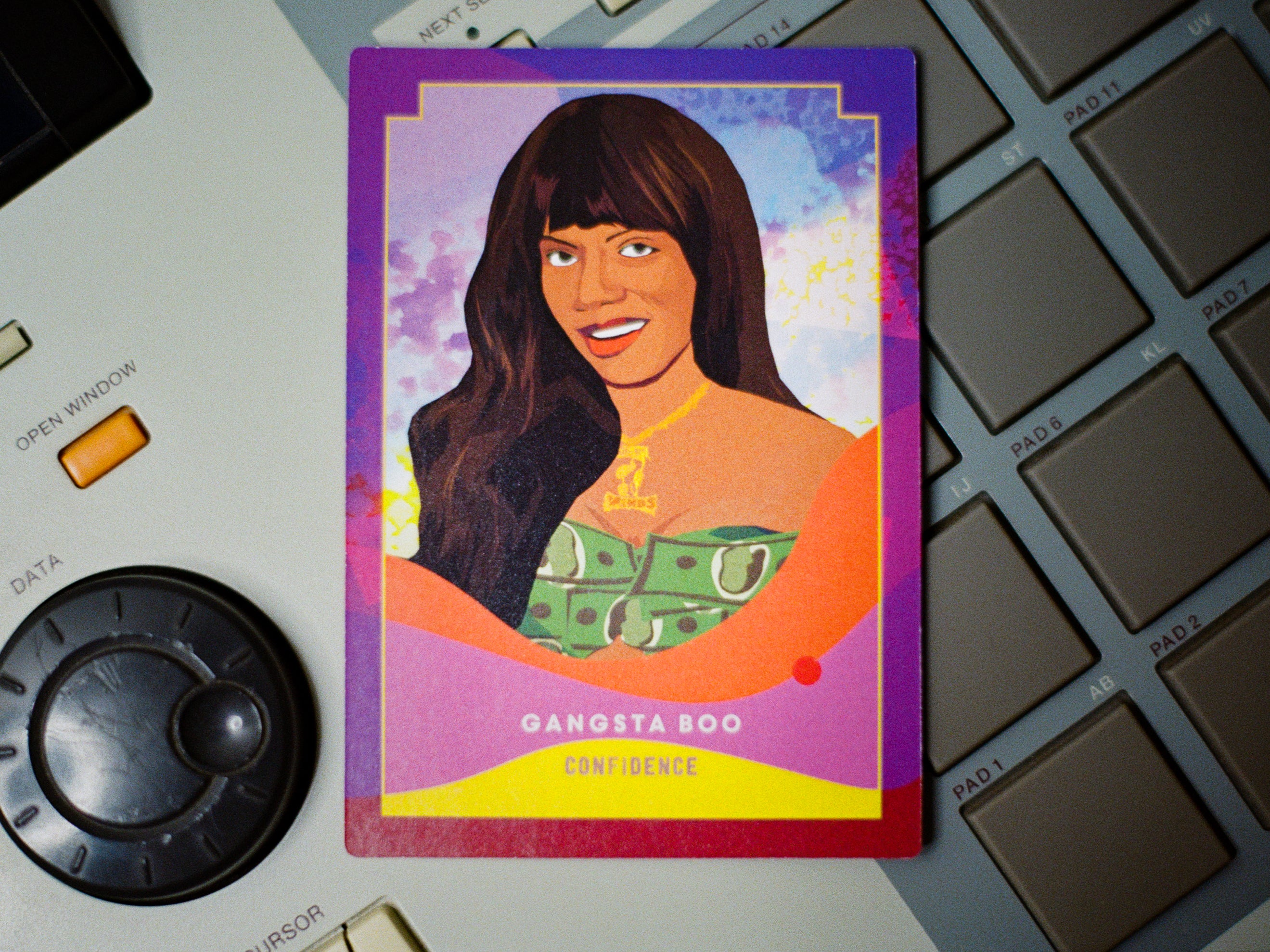 Card featuring a stylized illustration of a woman with text 'Gangsta Boo' on a keyboard and electronic device background.