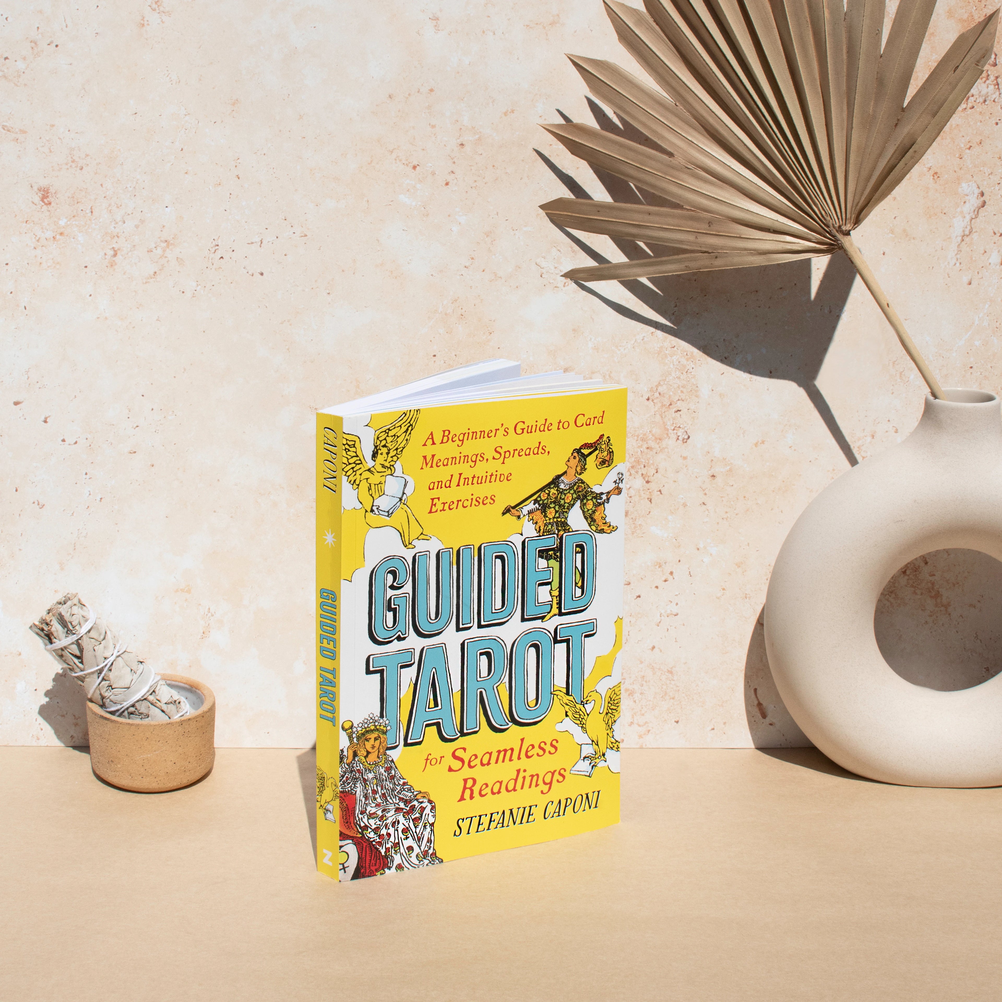 Book titled 'Guided Tarot' on a beige surface with decorative elements.