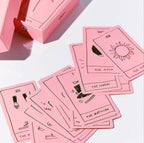 Pink tarot cards with illustrations on a white surface