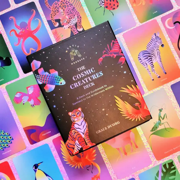 Cosmic Creatures Deck book surrounded by colorful tarot card illustrations