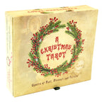A vintage-style boxed tarot card deck titled "A Christmas Tarot" with a cream-colored cover, red berry wreath illustration, and gothic text reading "Ghosts of Past, Present, and Future.".