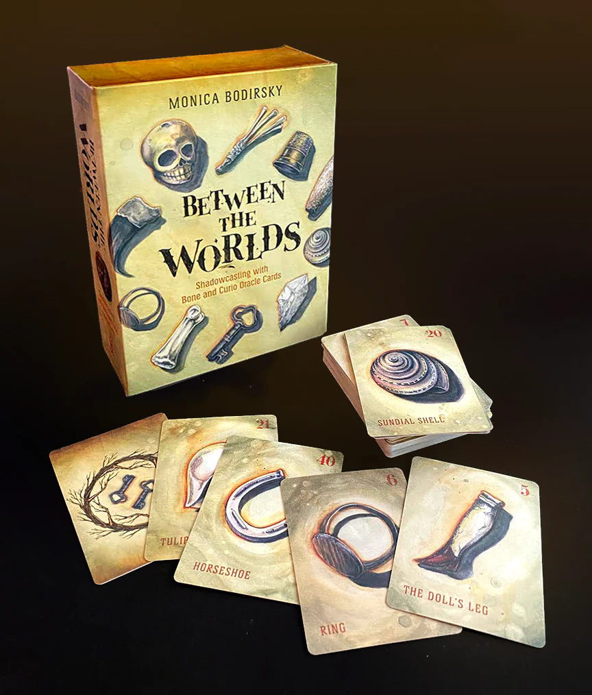 Card game set with cards and a box titled 'Between the Worlds' by Monica Bodisly.