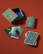 Card game set with bird-themed cards and a decorative box on a red background