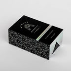 Black and white patterned box with 'Mystic Mondays' branding on a light gray background