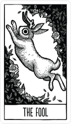 Tarot card featuring 'The Fool' with a goat and roses, black and white.