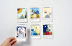 Collection of tarot cards displayed on a white surface with a hand holding one card.