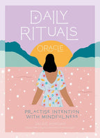 Book cover of 'Daily Rituals Oracle' with a person sitting under a sun and mountains.