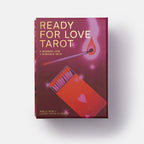 The 'Ready for Love Tarot' deck box by Amelia Ross and Lindsey Reyes-Chang, featuring a deep magenta and purple cover with gold lettering and illustrations of a match and hearts, set against a plain white background.