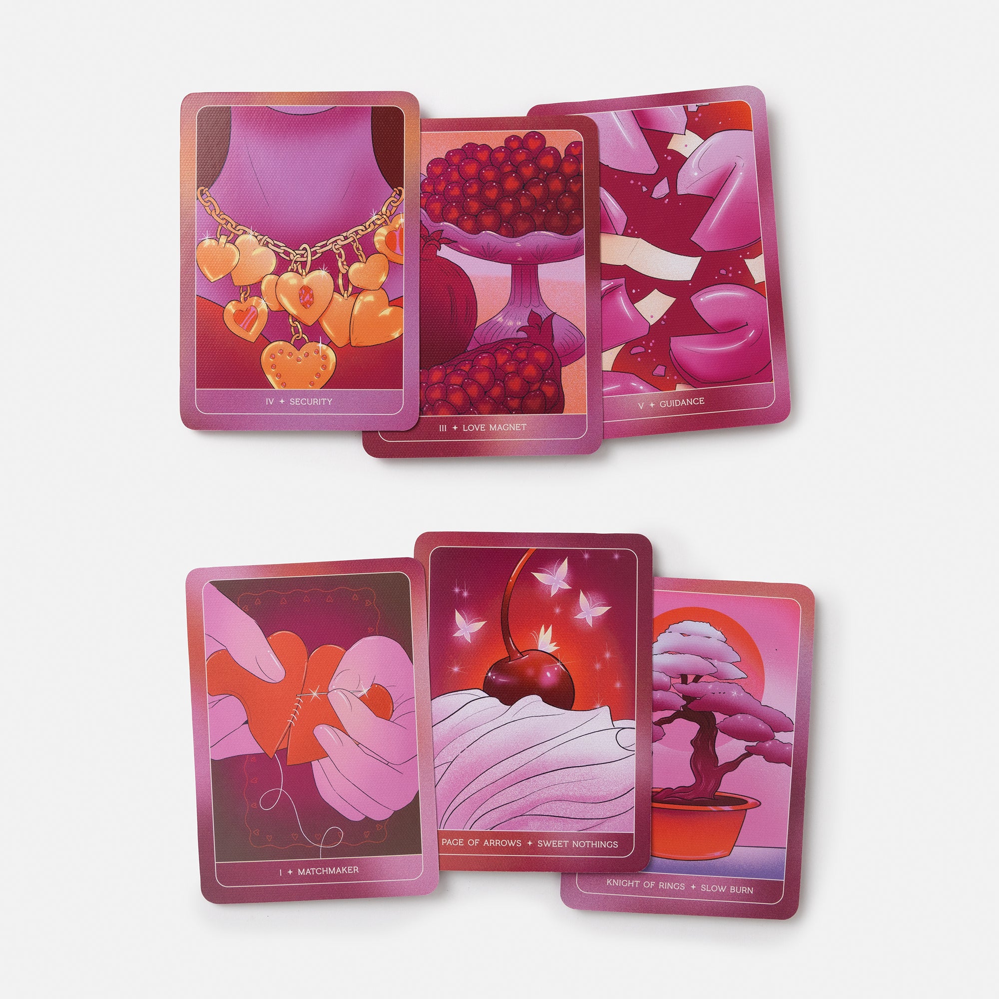 Six illustrated tarot-style cards arranged in two rows on a light gray background. The cards feature pink, magenta, and red tones with imagery including a heart pendant, berries, broken heart pieces, cherries, hands sewing, and a bonsai tree.