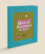 Book titled 'The Queer Animal Oracle Guidebook' with a teal cover on a beige background