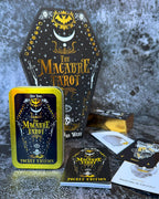 Macabre Tarot cards with coffin-shaped box on a textured surface