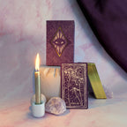 Magical setup with tarot cards, candle, and crystals on a soft pink background