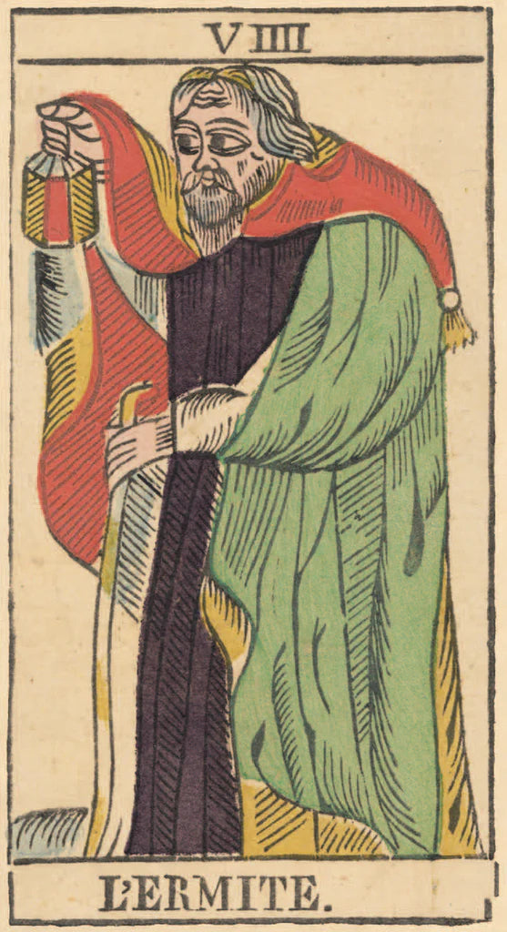 Card from a tarot deck featuring a figure labeled 'Lçermite' with colorful clothing.