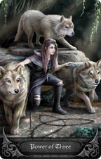 Woman sitting with three wolves on a stone platform, with 'Power of Three' text at the bottom.