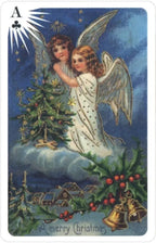 Vintage Christmas card with two angels, a tree, and bells against a blue sky.