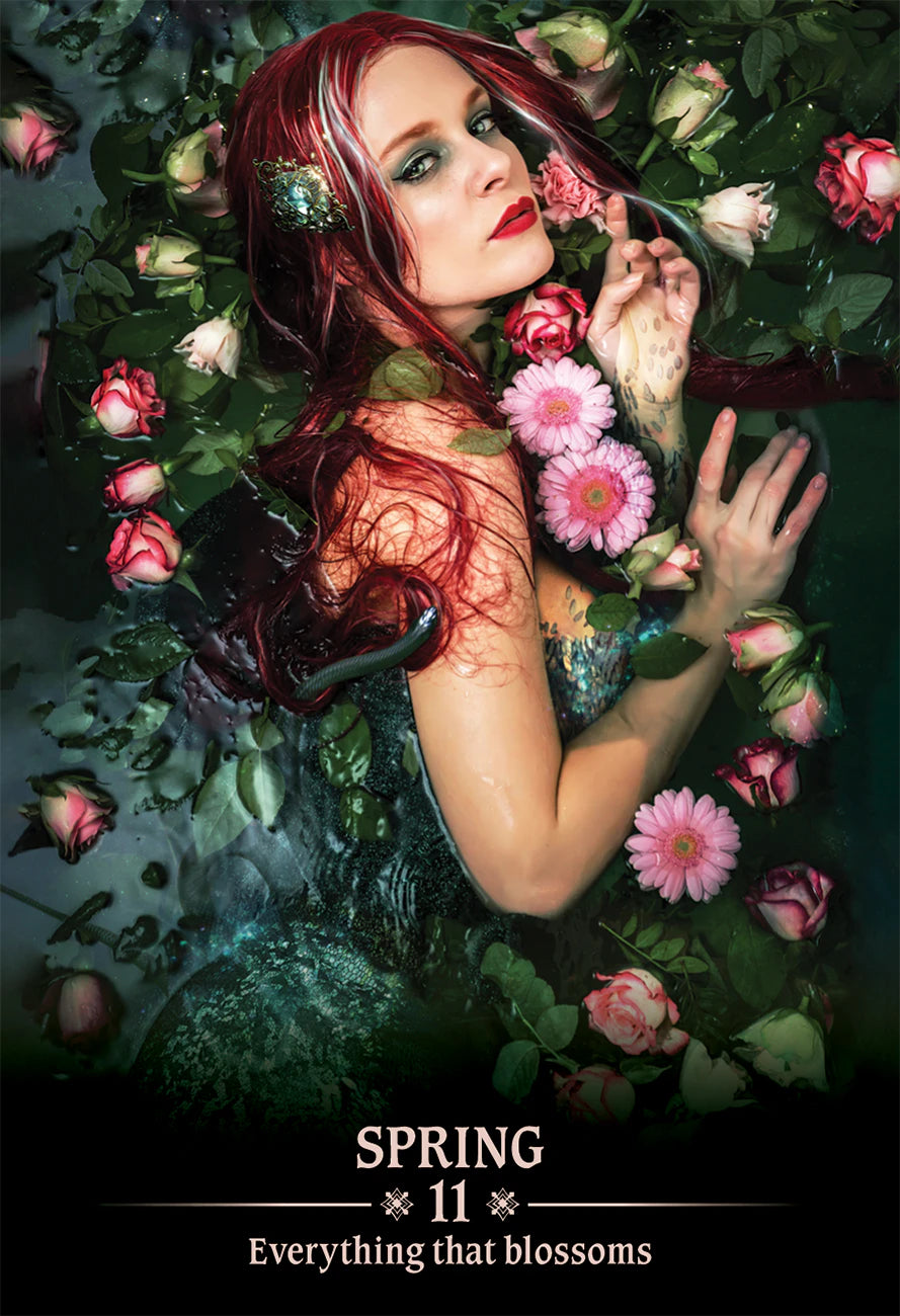 Woman with red hair and floral makeup surrounded by flowers with 'Spring 11' text.