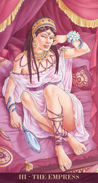 Tarot card featuring 'The Empress' with a woman in classical attire on a pink background.